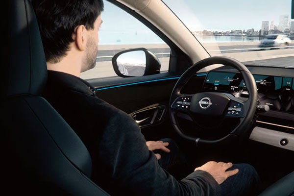 Man sitting in driver's seat of Nissan EV