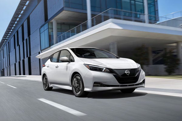 Nissan LEAF front view driving on road in front of building