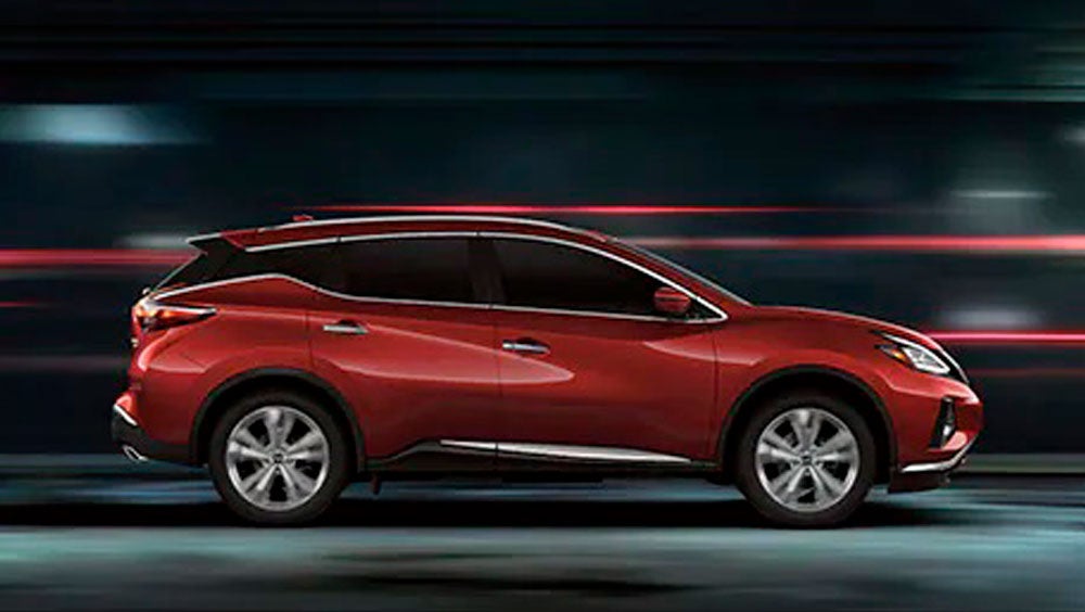 2023 Nissan Murano shown in profile driving down a street at night illustrating performance. | Merchant Nissan in Troy AL